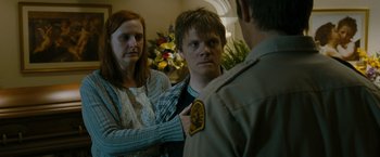 Movie still from “The Crazies” (2010), directed by Breck Eisner – A man and a woman standing in front of another man; Close Up shot, Over the shoulder angle