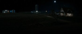 Movie still from “The Crazies” (2010), directed by Breck Eisner – A farm field with a silo in the background at night; Extreme Wide shot, High angle