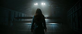 Movie still from “The Crazies” (2010), directed by Breck Eisner – A woman standing in front of an escalator at night; Medium shot, Low angle