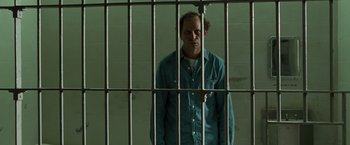 Movie still from “The Crazies” (2010), directed by Breck Eisner – A man standing behind bars in a jail cell; Medium shot, Low angle