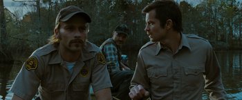 Movie still from “The Crazies” (2010), directed by Breck Eisner – A group of men sitting next to each other on a boat; Medium shot, Over the shoulder angle