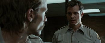 Movie still from “The Crazies” (2010), directed by Breck Eisner – Two men in uniform looking at each other in front of a mirror; Close Up shot, Over the shoulder angle