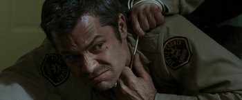 Movie still from “The Crazies” (2010), directed by Breck Eisner – A person putting a cord in their ear; Close Up shot, High angle