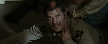 Movie still from “The Crazies” (2010), directed by Breck Eisner – A man in a police uniform with his eyes wide open; Close Up shot, Over the shoulder angle