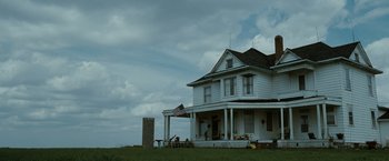 Movie still from “The Crazies” (2010), directed by Breck Eisner – An american flag hanging from a porch of a white house; Extreme Wide shot, Low angle