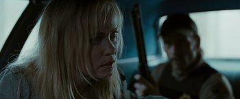Movie still from “The Crazies” (2010), directed by Breck Eisner – A woman holding a gun while sitting next to another woman; Close Up shot, Over the shoulder angle