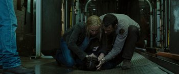 Movie still from “The Crazies” (2010), directed by Breck Eisner – A man and a woman kneeling down on the ground; Medium shot, High angle