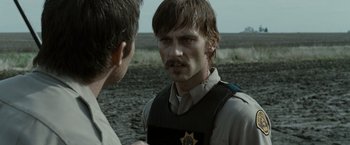 Movie still from “The Crazies” (2010), directed by Breck Eisner – A man in a sheriff's uniform talking to another man; Close Up shot, Over the shoulder angle