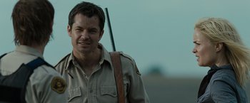 Movie still from “The Crazies” (2010), directed by Breck Eisner – A man in a uniform holding a rifle in his hand; Close Up shot, Over the shoulder angle