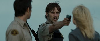 Movie still from “The Crazies” (2010), directed by Breck Eisner – A man holding a gun in his hand and a gun in his other hand; Close Up shot, Over the shoulder angle