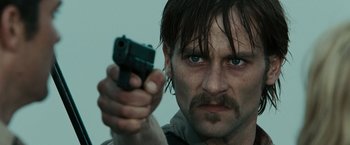 Movie still from “The Crazies” (2010), directed by Breck Eisner – A person holding a gun; Close Up shot, Low angle