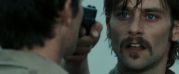 Movie still from “The Crazies” (2010), directed by Breck Eisner – A man holding a gun in front of another man's face; Close Up shot, Over the shoulder angle