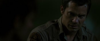 Movie still from “The Crazies” (2010), directed by Breck Eisner – A person wearing a police uniform; Close Up shot, Over the shoulder angle