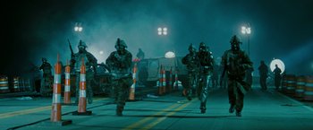 Movie still from “The Crazies” (2010), directed by Breck Eisner – A group of soldiers walking down a street at night; Wide shot, High angle