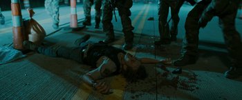 Movie still from “The Crazies” (2010), directed by Breck Eisner – A man laying on the ground in the middle of the street; Medium shot, High angle