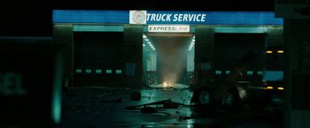 Movie still from “The Crazies” (2010), directed by Breck Eisner – A truck service station with a fire in the background; Extreme Wide shot, Low angle