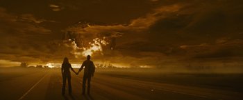 Movie still from “The Crazies” (2010), directed by Breck Eisner – Two people holding hands on the side of a road; Wide shot, Over the shoulder angle