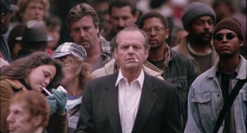 Movie still from “The Crossing Guard” (1995), directed by Sean Penn – A crowd of people walking down a street; Medium shot, Over the shoulder angle