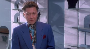 Movie still from “The Crossing Guard” (1995), directed by Sean Penn – A man in a blue suit and a red and white tie; Close Up shot, Low angle