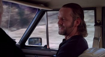 Movie still from “The Crossing Guard” (1995), directed by Sean Penn – A man sitting in the driver's seat of a car; Close Up shot, Over the shoulder angle