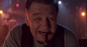 Movie still from “The Crossing Guard” (1995), directed by Sean Penn – An older man smoking a cigar in a dark room; Close Up shot, Low angle