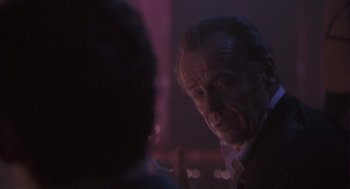 Movie still from “The Crossing Guard” (1995), directed by Sean Penn – A man is looking at a woman in a purple light; Close Up shot, Over the shoulder angle