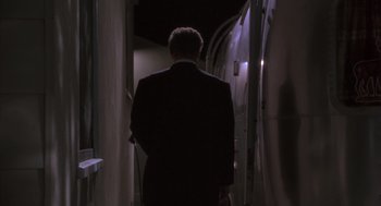 Movie still from “The Crossing Guard” (1995), directed by Sean Penn – A man in a suit is walking down a dark hallway; Medium shot, Low angle