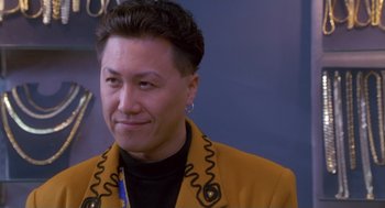 Movie still from “The Crossing Guard” (1995), directed by Sean Penn – A man in a yellow jacket is smiling for the camera; Close Up shot, Low angle