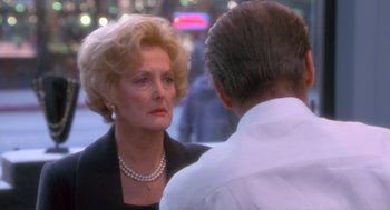 Movie still from “The Crossing Guard” (1995), directed by Sean Penn – An older woman talking to an older man in a suit; Close Up shot, Over the shoulder angle