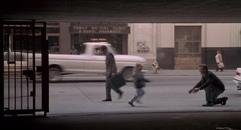 Movie still from “The Crossing Guard” (1995), directed by Sean Penn – A man and a woman walking down a street; Wide shot, High angle