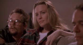 Movie still from “The Crossing Guard” (1995), directed by Sean Penn – A woman sitting on a chair in a room; Close Up shot, Over the shoulder angle