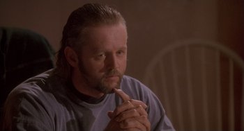 Movie still from “The Crossing Guard” (1995), directed by Sean Penn – A man sitting down with his hands clasped together; Close Up shot, Low angle