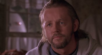Movie still from “The Crossing Guard” (1995), directed by Sean Penn – A person with long hair and a beard; Close Up shot, Low angle