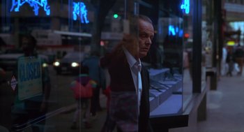 Movie still from “The Crossing Guard” (1995), directed by Sean Penn – A man standing in front of a store window at night; Medium shot, Low angle