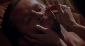 Movie still from “The Crossing Guard” (1995), directed by Sean Penn – A person laying on a bed with their eyes closed; Extreme Close Up shot, Over the shoulder angle