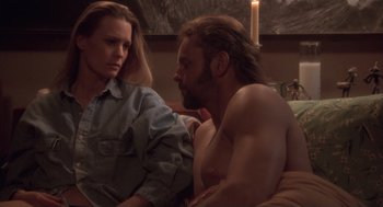 Movie still from “The Crossing Guard” (1995), directed by Sean Penn – A man and a woman sitting on a couch; Medium shot, Low angle