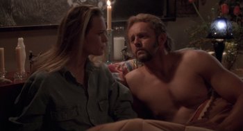 Movie still from “The Crossing Guard” (1995), directed by Sean Penn – A man and a woman sitting on a couch; Medium shot, Over the shoulder angle