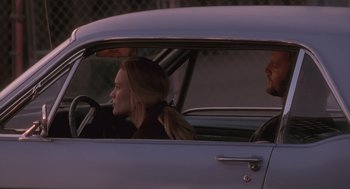 Movie still from “The Crossing Guard” (1995), directed by Sean Penn – A woman sitting in the driver's seat of a car; Medium shot, Over the shoulder angle