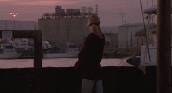 Movie still from “The Crossing Guard” (1995), directed by Sean Penn – A woman looking out over a body of water at dusk; Wide shot, Over the shoulder angle