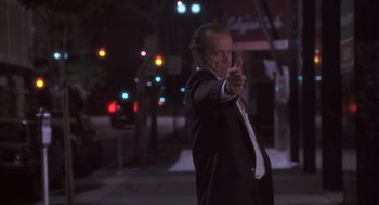 Movie still from “The Crossing Guard” (1995), directed by Sean Penn – A man in a suit and tie pointing at the camera; Medium shot, Low angle