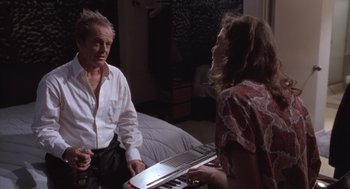 Movie still from “The Crossing Guard” (1995), directed by Sean Penn – A man and a woman sitting on a bed with a keyboard; Medium shot, High angle