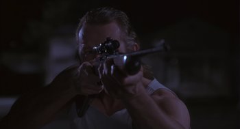 Movie still from “The Crossing Guard” (1995), directed by Sean Penn – A man is aiming a rifle at a target; Close Up shot, Low angle