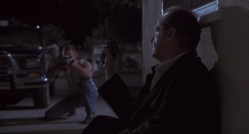 Movie still from “The Crossing Guard” (1995), directed by Sean Penn – A man holding a gun while another man holds a rifle; Wide shot, Over the shoulder angle