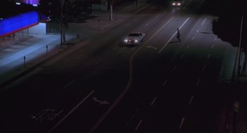 Movie still from “The Crossing Guard” (1995), directed by Sean Penn – A white car driving down a street at night; Extreme Wide shot, High angle