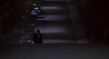 Movie still from “The Crossing Guard” (1995), directed by Sean Penn – A man in a suit standing on the side of a road; Extreme Wide shot, Low angle