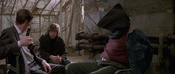 Movie still from “The Crying Game” (1992), directed by Neil Jordan – A group of people sitting on the ground in a building; Medium shot, Over the shoulder angle