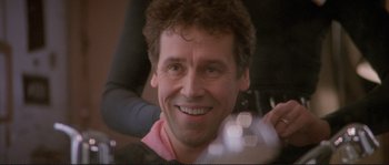 Movie still from “The Crying Game” (1992), directed by Neil Jordan – A person smiling; Close Up shot, Over the shoulder angle