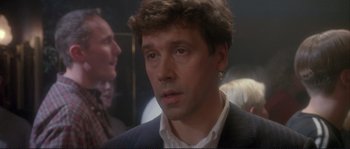 Movie still from “The Crying Game” (1992), directed by Neil Jordan – A person wearing a suit and tie; Close Up shot, Over the shoulder angle