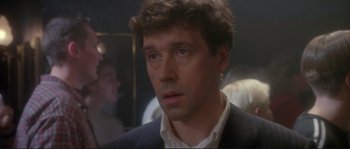 Movie still from “The Crying Game” (1992), directed by Neil Jordan – A person wearing a suit and tie; Close Up shot, Over the shoulder angle