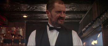Movie still from “The Crying Game” (1992), directed by Neil Jordan – A person wearing a vest and a bow tie; Close Up shot, Low angle